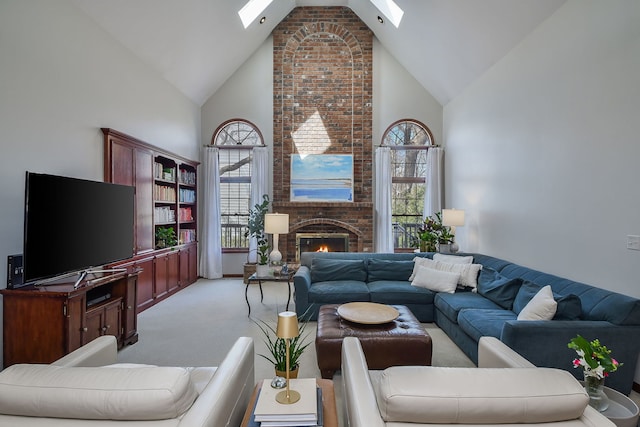 living room featuring a brick fireplace, high vaulted ceiling, light colored carpet, and a skylight