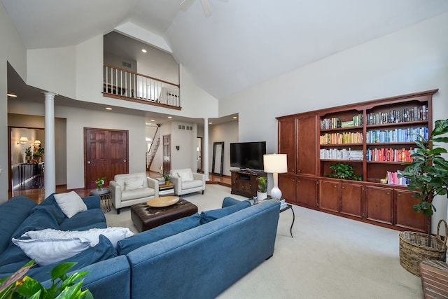 living room featuring ornate columns, high vaulted ceiling, visible vents, and light carpet