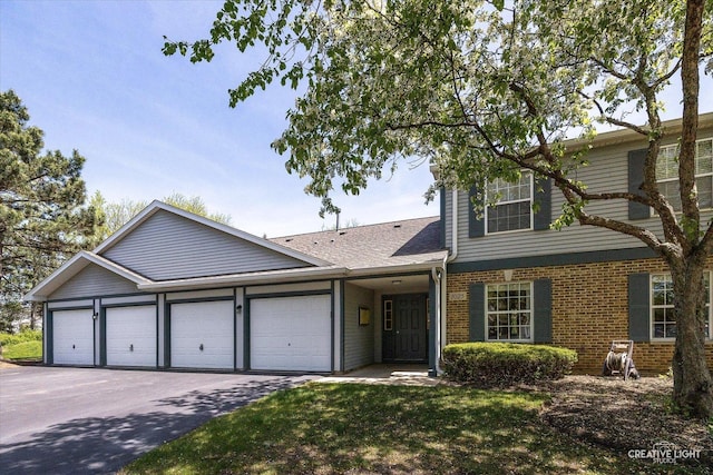 1025 Chaucer Ct E Unit B, Elgin, IL 60120 - view of front facade with an attached garage, asphalt driveway, brick siding, and roof with shingles