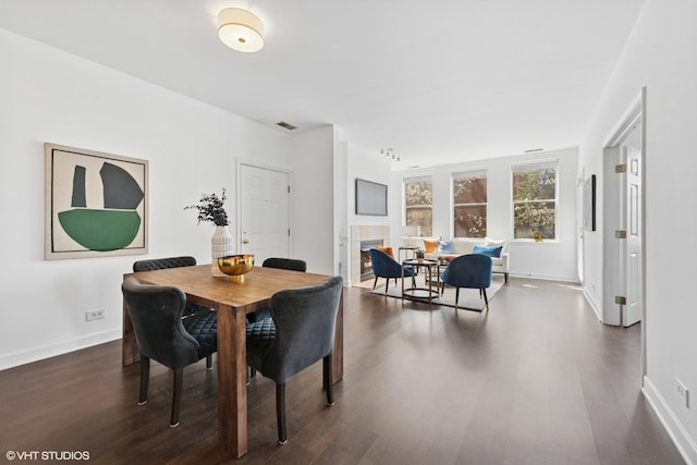 dining space with baseboards, dark wood-style flooring, and visible vents