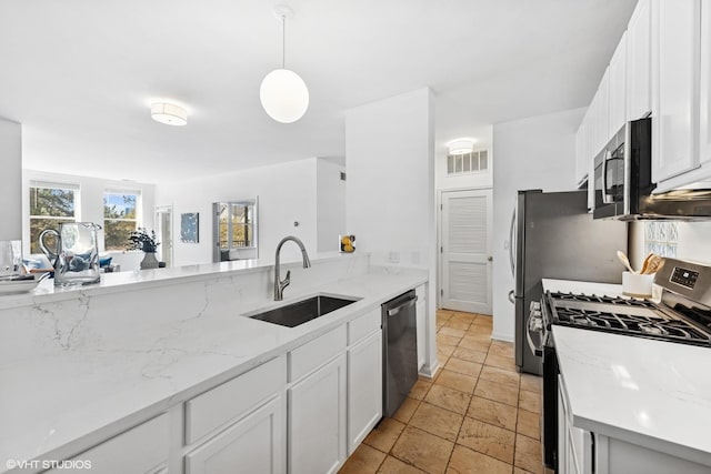 kitchen with white cabinets, stainless steel appliances, hanging light fixtures, and a sink