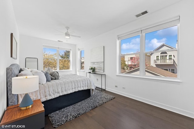 bedroom featuring baseboards, ceiling fan, dark wood-style floors, and visible vents