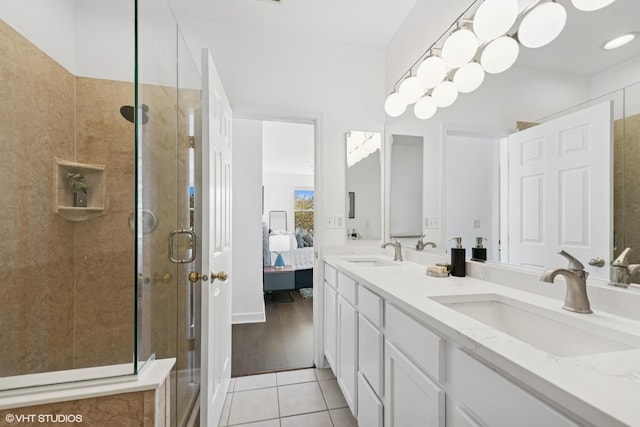 ensuite bathroom featuring tile patterned floors, a shower stall, a sink, and ensuite bath