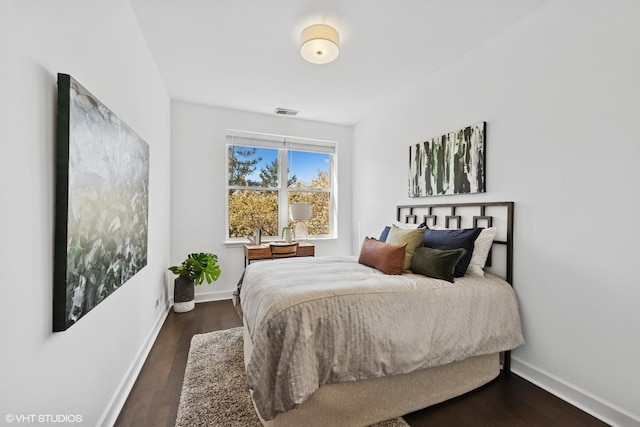 bedroom featuring baseboards, dark wood finished floors, and visible vents
