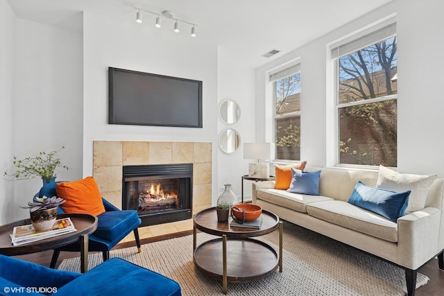 living room featuring visible vents, track lighting, and a tile fireplace