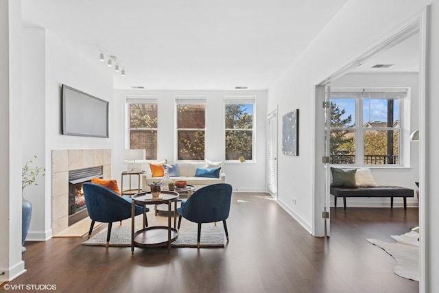 dining room with track lighting, baseboards, dark wood-style floors, and a fireplace