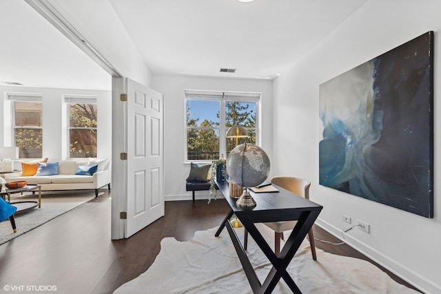 office area featuring visible vents, baseboards, and wood finished floors