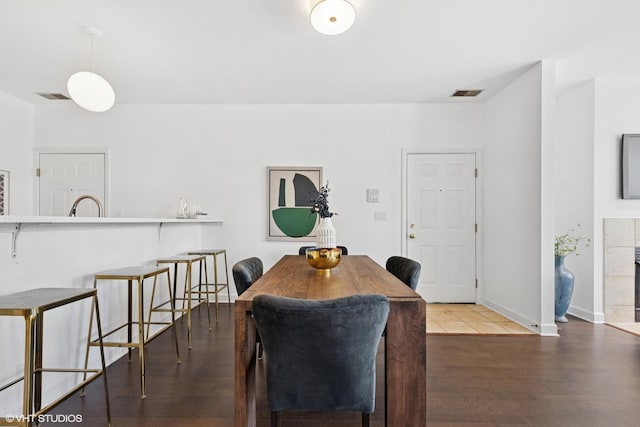 dining area featuring baseboards, wood finished floors, and visible vents