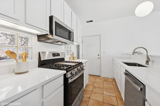 kitchen with stainless steel appliances, visible vents, white cabinetry, and a sink