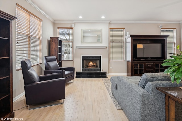 living room featuring crown molding, baseboards, a fireplace, and hardwood / wood-style floors