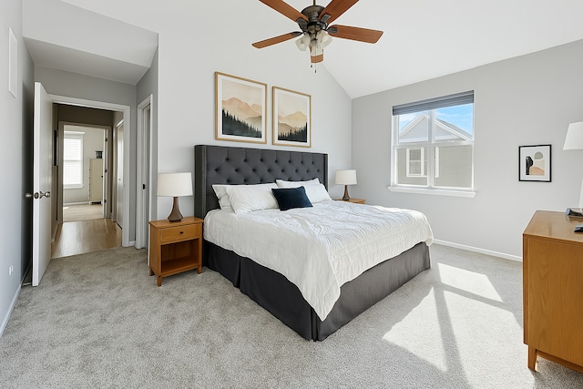 bedroom with light colored carpet, baseboards, lofted ceiling, and multiple windows