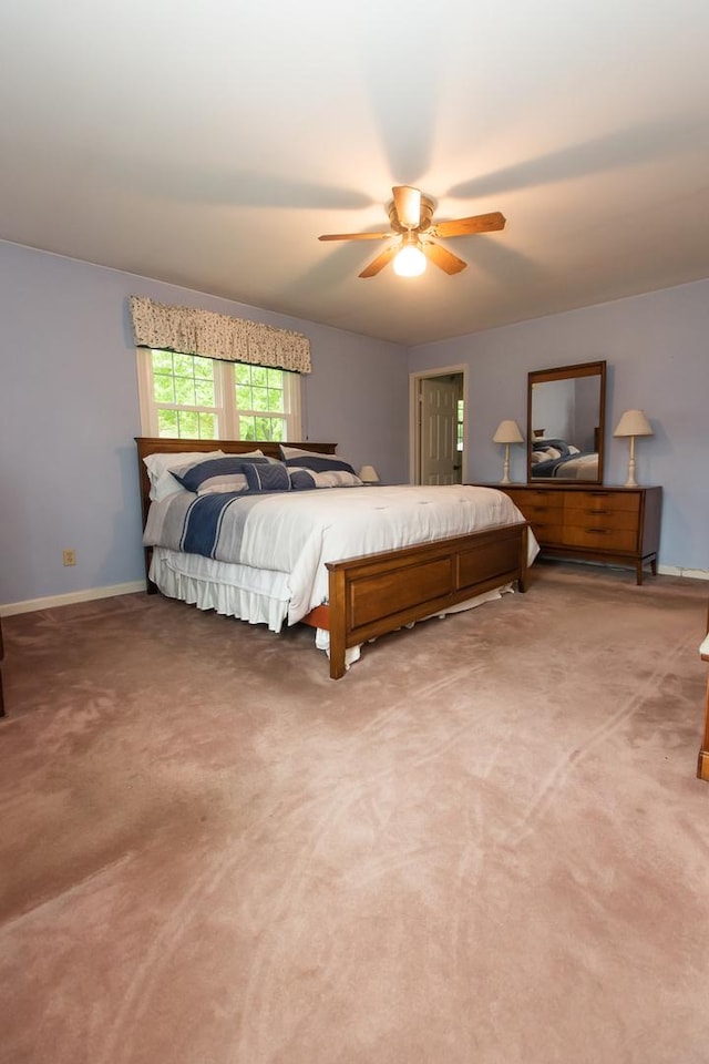 bedroom featuring baseboards, ceiling fan, and light carpet