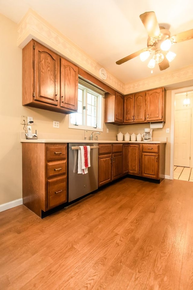 kitchen featuring brown cabinetry, light wood-type flooring, light countertops, a ceiling fan, and dishwasher