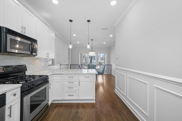 2515 W Harrison St Unit 1, Chicago, IL 60612 - kitchen with appliances with stainless steel finishes, a peninsula, dark wood-style floors, ornamental molding, and white cabinetry