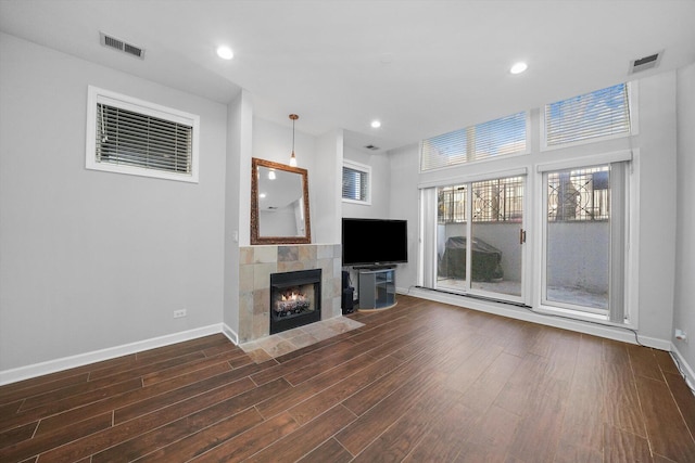 2515 W Harrison St Unit 1, Chicago, IL 60612 - unfurnished living room with baseboards, dark wood-style flooring, a tile fireplace, and visible vents