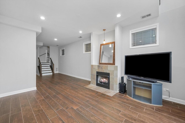 2515 W Harrison St Unit 1, Chicago, IL 60612 - unfurnished living room featuring recessed lighting, baseboards, wood finished floors, a tile fireplace, and stairway