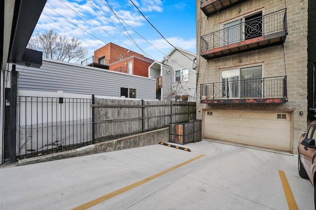 2515 W Harrison St Unit 1, Chicago, IL 60612 - view of patio with driveway, fence, a balcony, and a garage
