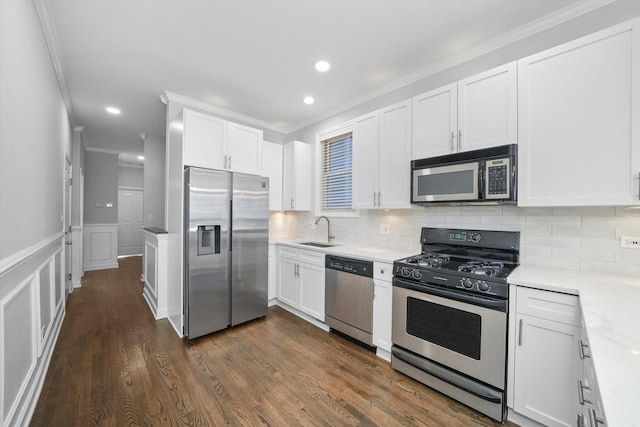 2515 W Harrison St Unit 1, Chicago, IL 60612 - kitchen with backsplash, appliances with stainless steel finishes, a sink, ornamental molding, and white cabinetry