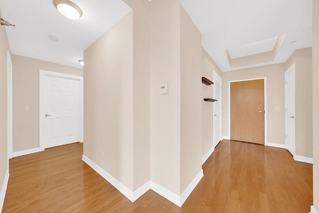 hallway featuring baseboards and light wood finished floors