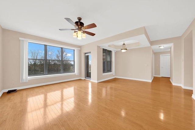 empty room with baseboards, light wood-style floors, and ceiling fan
