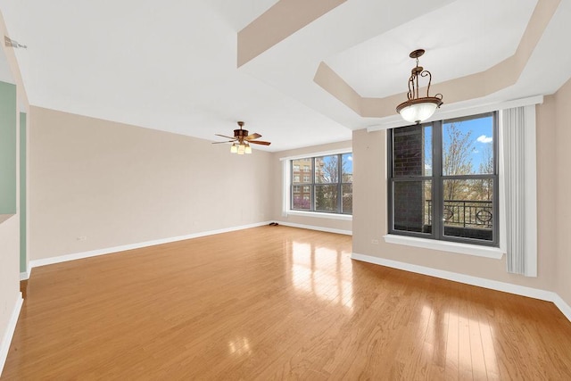 spare room featuring light wood-style floors, baseboards, and ceiling fan