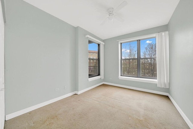 empty room featuring carpet floors, baseboards, and ceiling fan