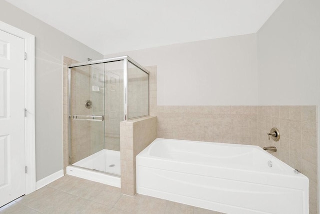 bathroom with tile patterned flooring, a garden tub, and a stall shower