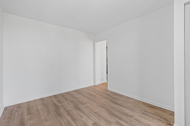 empty room with baseboards and light wood-style floors