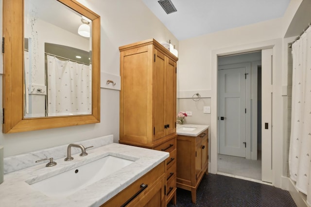 bathroom with a sink, a shower with curtain, two vanities, and visible vents