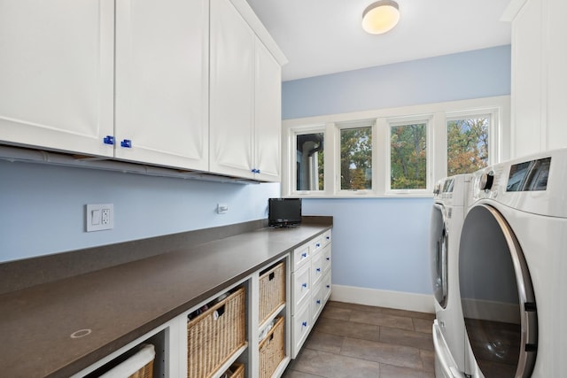 laundry room with baseboards, cabinet space, and washing machine and dryer