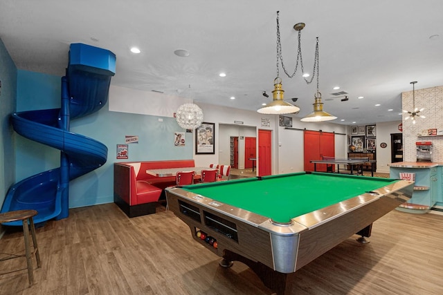 game room with a barn door, billiards, recessed lighting, and wood finished floors