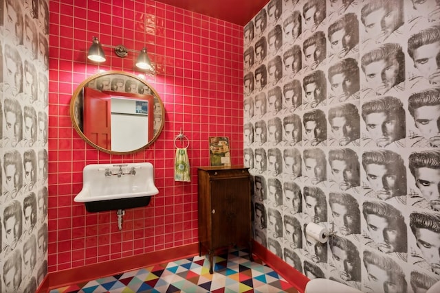 bathroom with tile walls and a sink