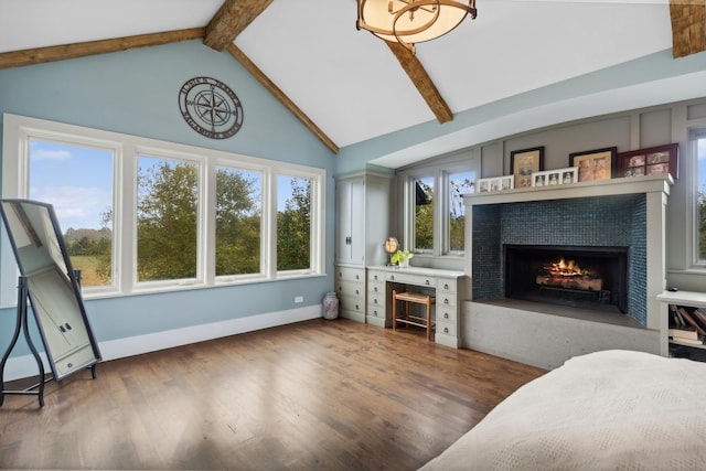 living room with plenty of natural light, beam ceiling, and a tile fireplace