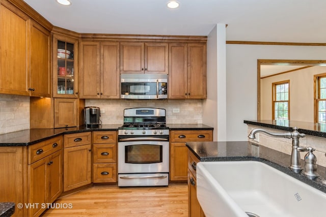 6S475 Sussex Rd, Naperville, IL 60540 - kitchen featuring stainless steel appliances, brown cabinetry, dark stone counters, recessed lighting, and ornamental molding