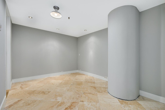 spare room featuring baseboards and stone finish flooring