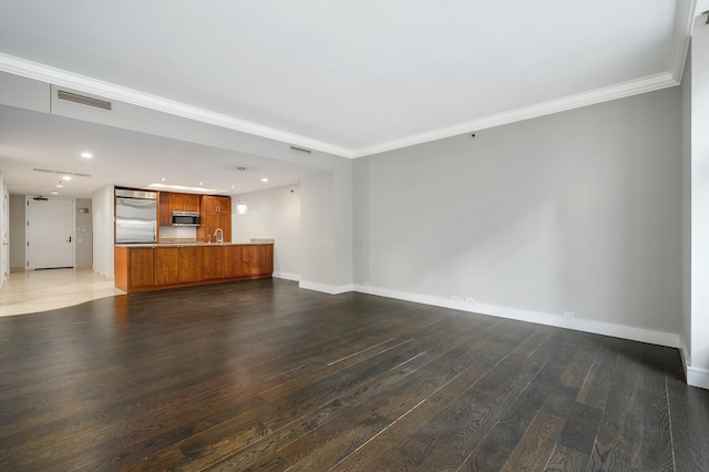 unfurnished living room featuring baseboards, ornamental molding, and hardwood / wood-style flooring