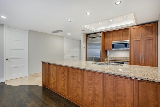 kitchen with brown cabinets, a sink, stainless steel appliances, recessed lighting, and visible vents