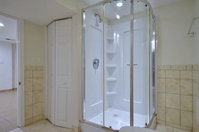 7840 W Cressett Dr, Elmwood Park, IL 60707 - full bathroom with tile walls, a stall shower, tile patterned flooring, a closet, and a wainscoted wall