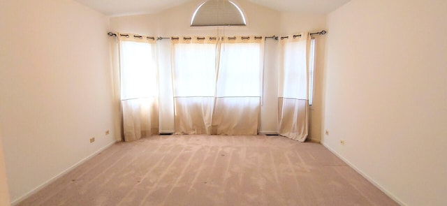 empty room with baseboards, carpet, and vaulted ceiling