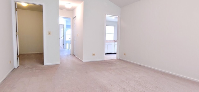 unfurnished bedroom with carpet floors, baseboards, and connected bathroom
