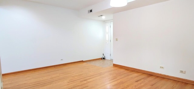 empty room with baseboards, light wood-style flooring, and visible vents