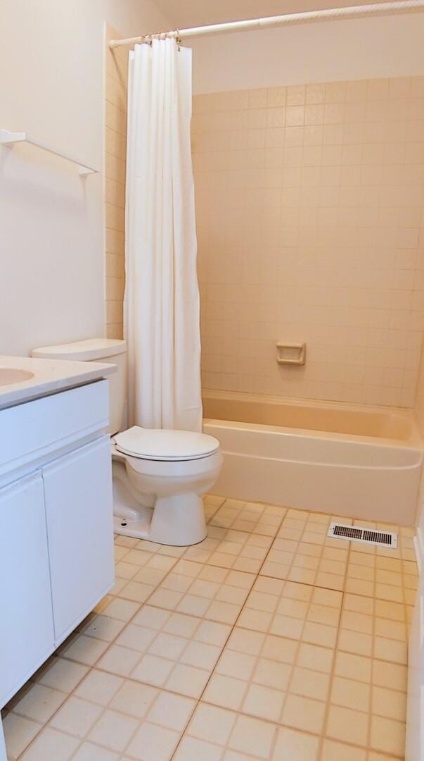 bathroom featuring visible vents, shower / tub combo, tile patterned floors, vanity, and toilet