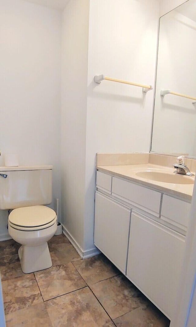 bathroom with toilet, baseboards, tile patterned floors, and vanity