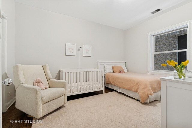 bedroom with visible vents and wood finished floors