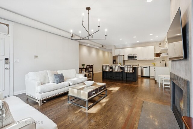 living area with an inviting chandelier, baseboards, dark wood-style flooring, and recessed lighting