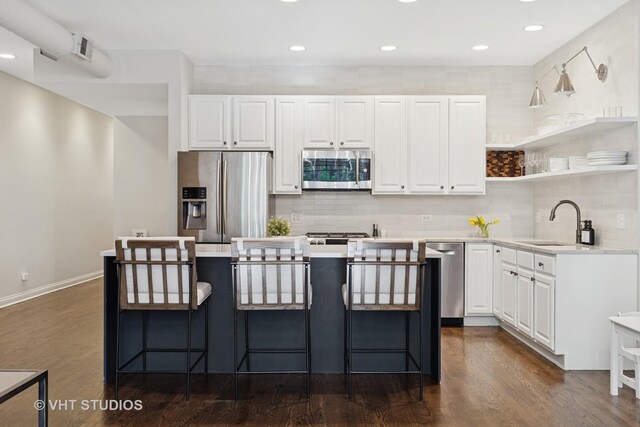kitchen featuring dark wood-type flooring, a sink, white cabinetry, and appliances with stainless steel finishes