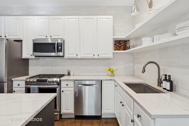 kitchen featuring a sink, open shelves, appliances with stainless steel finishes, and white cabinets