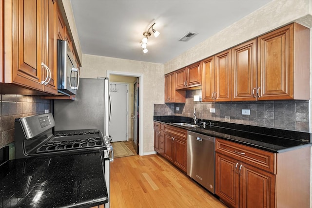 387 Coventrey Ct Unit 0, Clarendon Hills, IL 60514 - kitchen with stainless steel appliances, a sink, brown cabinets, light wood-style flooring, and backsplash