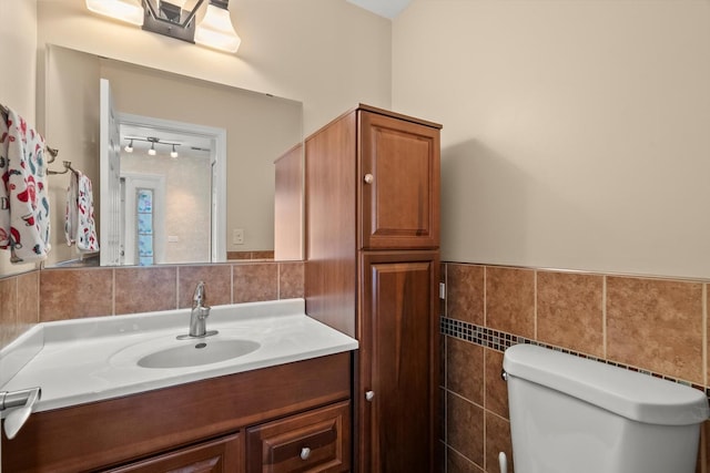 387 Coventrey Ct Unit 0, Clarendon Hills, IL 60514 - half bathroom featuring tile walls, toilet, vanity, and wainscoting