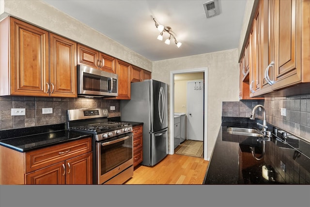 387 Coventrey Ct Unit 0, Clarendon Hills, IL 60514 - kitchen featuring stainless steel appliances, a sink, independent washer and dryer, light wood-type flooring, and brown cabinetry